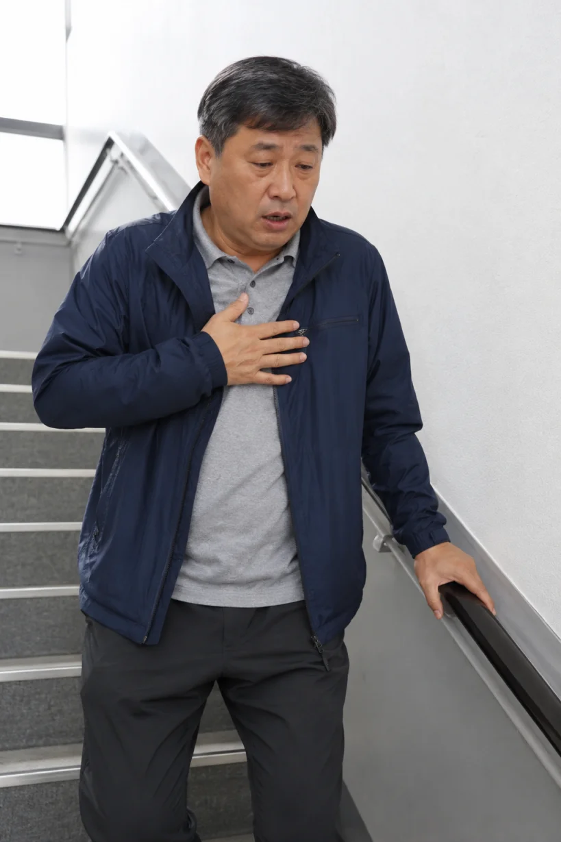 계단을 오르며 숨이 차는 50대 남성의 모습