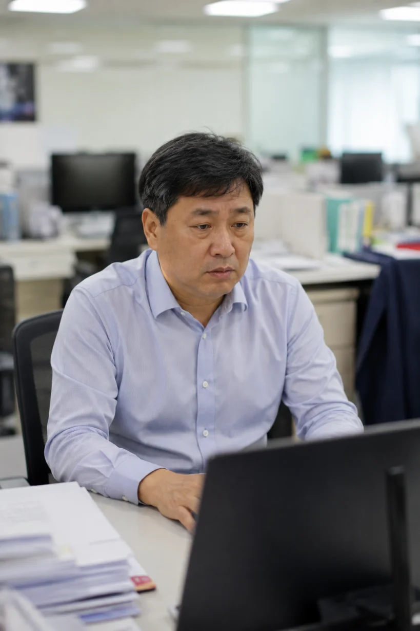 사무실에서 오래 앉아 일하는 50대 직장인의 모습