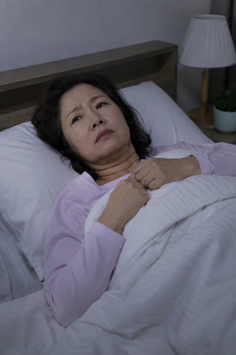 잠들지 못하고 뒤척이는 50대 여성의 모습