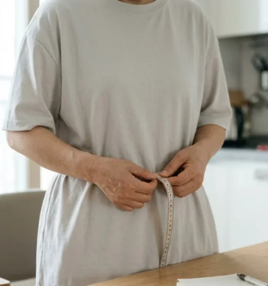 줄자로 허리둘레를 재고 기록하는 모습